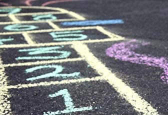 Děti kreslící chodníkovými křídami Colorino venku